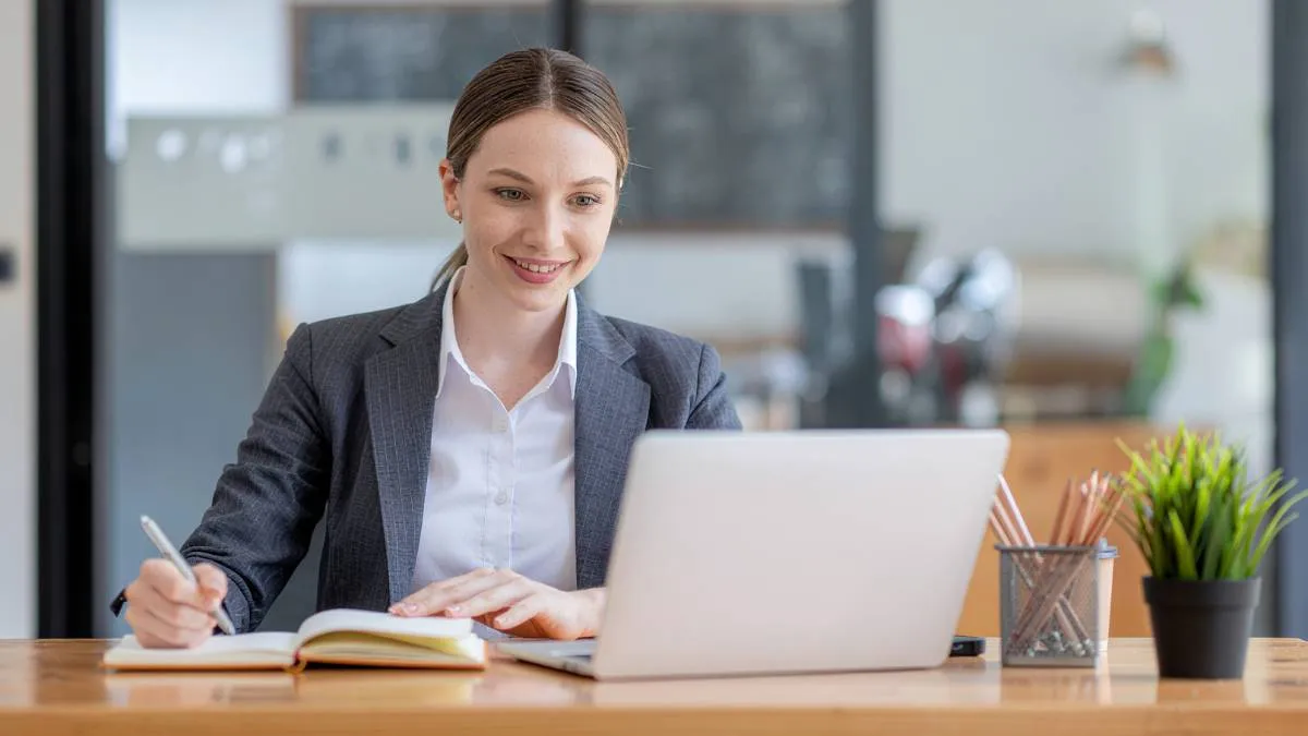 Professional reviewing email on laptop with confident expression